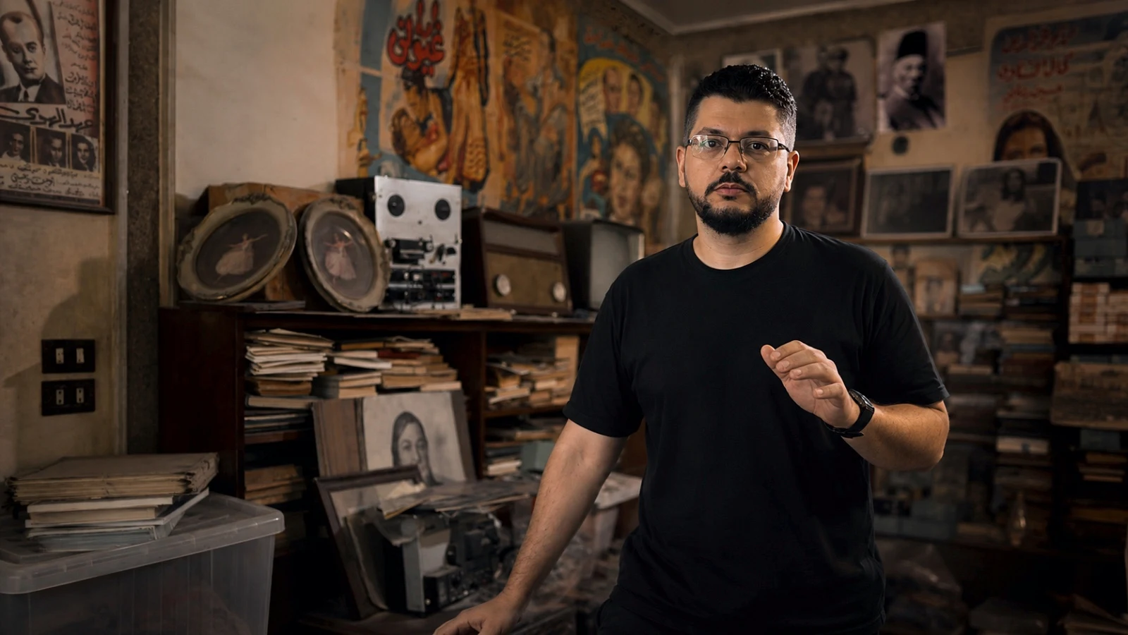 Omar Ahmed Khodier among archive film posters, reels and projection equipment in Cairo